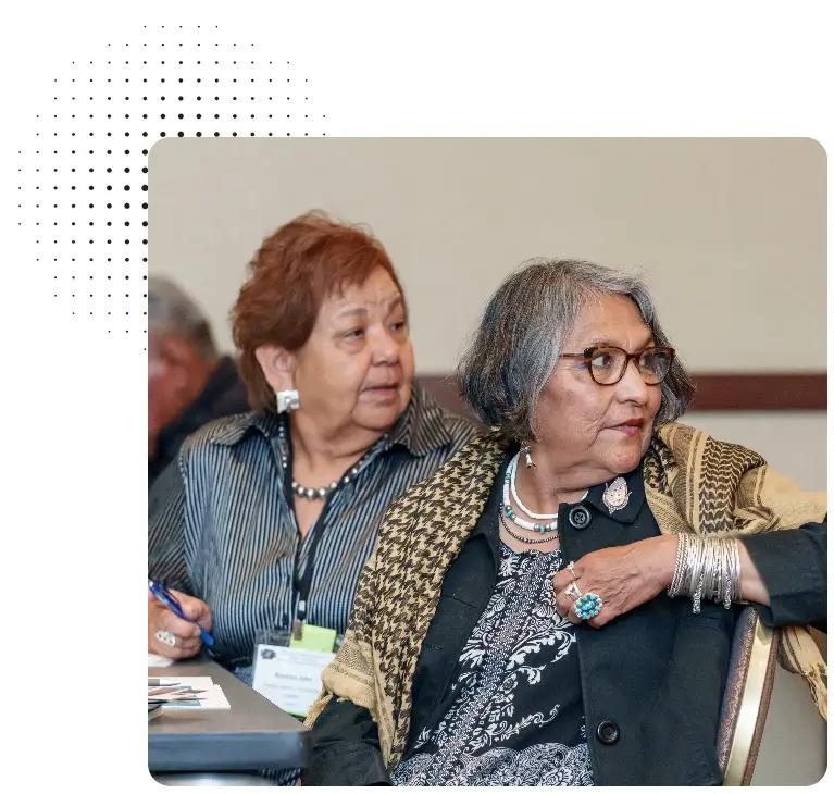 Two women sitting next to each other at a table.