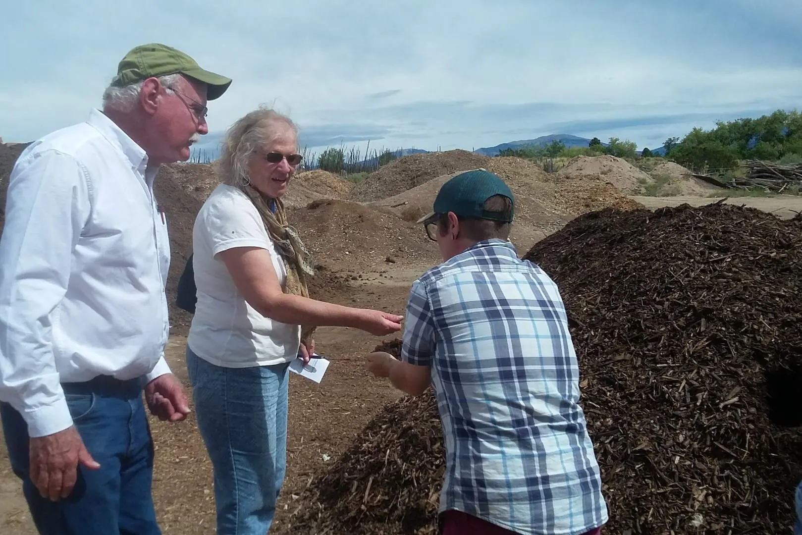 A group of people standing around some dirt