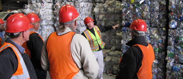 A group of people standing around in a warehouse.