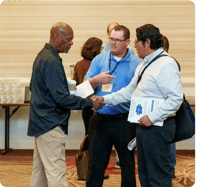 A group of people standing around shaking hands.